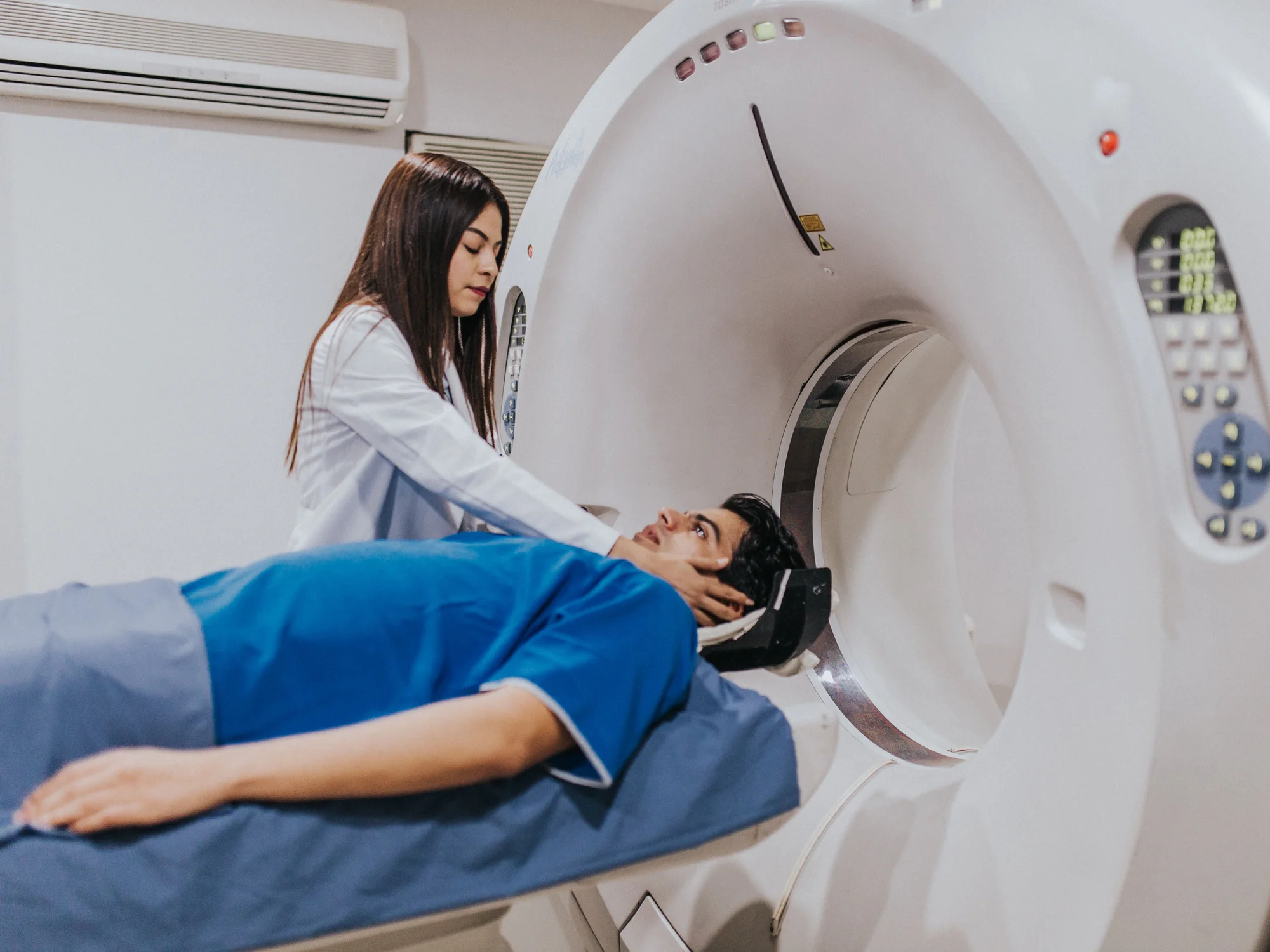 Radiographer positioning a patient in a CT scanner
